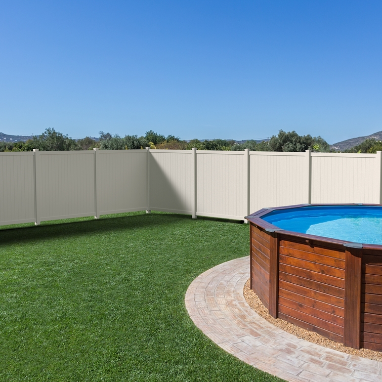 Cambridge white vinyl privacy fence installed around a backyard pool and patio area.