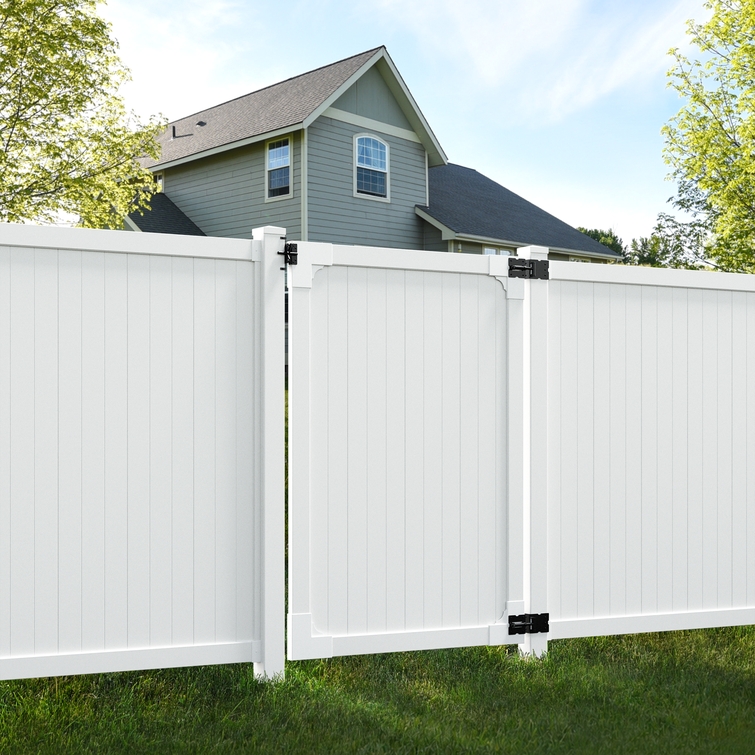Installed Cambridge white vinyl privacy gate shown between matching privacy fence panels in a residential yard.