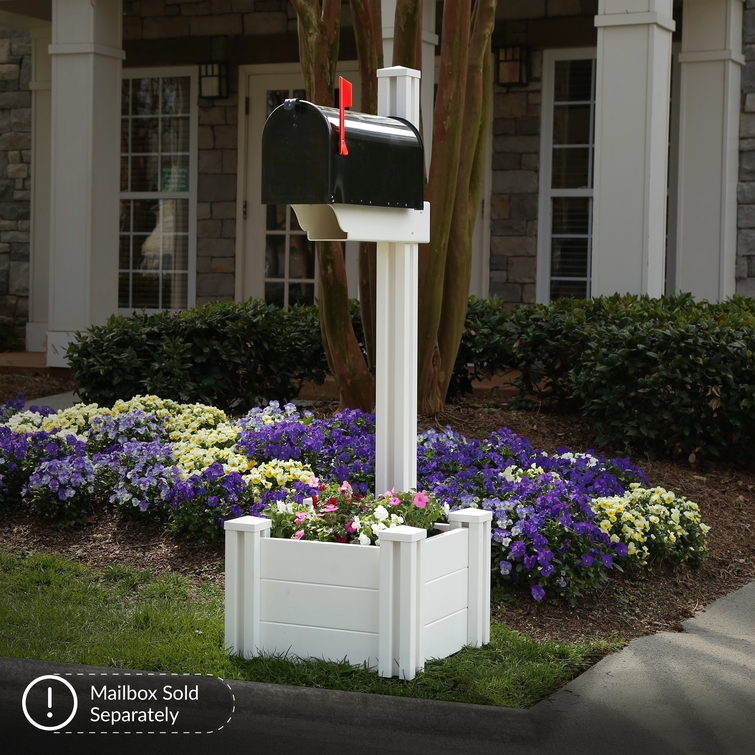 White vinyl mailbox post with integrated planter box installed in landscaped front yard with flowers