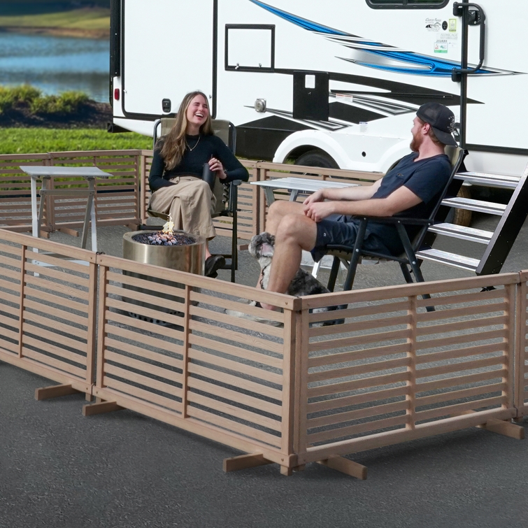 Freestanding WoodTek vinyl fence enclosure creating outdoor patio seating area for RV campsite