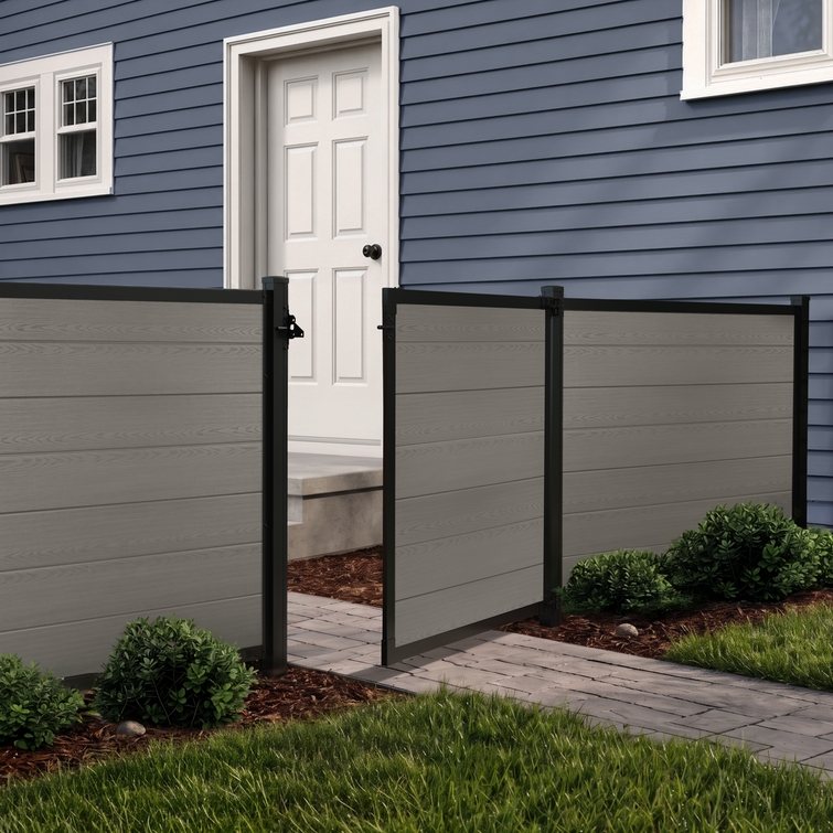 4 ft tall composite privacy fence with slate gray composite boards, black aluminum frame, and matching walk gate installed in a residential backyard.