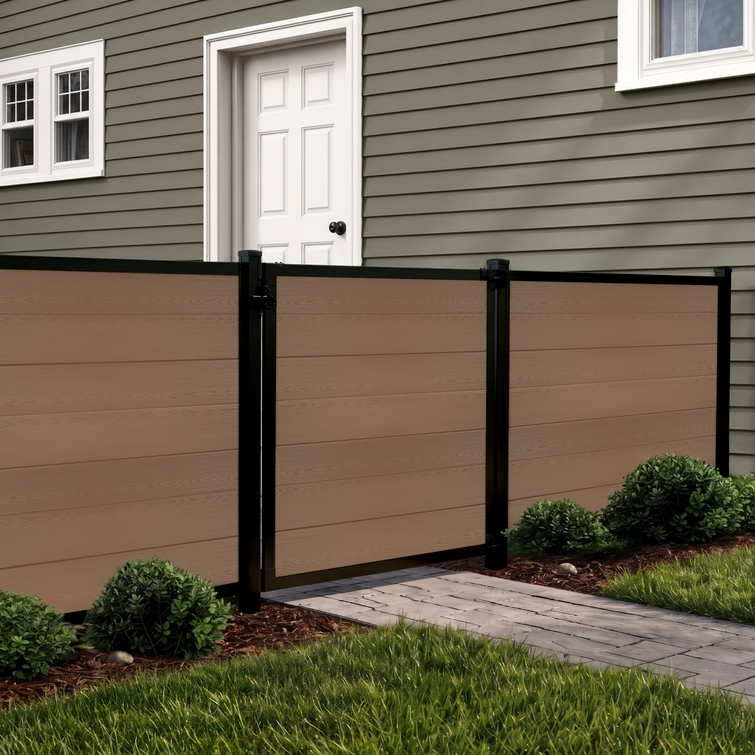 4 ft tall composite privacy fence with walnut brown composite boards, black aluminum frame, and closed matching walk gate in a residential backyard.