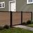4 ft tall composite privacy fence with walnut brown composite boards, black aluminum frame, and closed matching walk gate in a residential backyard.