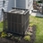 Outdoor air conditioner privacy screen enclosure with wood-look vertical slat panels and durable weather-resistant design