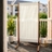 Freestanding outdoor privacy screen with ivory fabric panel and wood frame positioned on an apartment balcony for added privacy and shade.