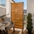 Enclo wood privacy fence screen installed on an outdoor balcony, featuring horizontal cedar-tone slats and a black metal frame for patio privacy, deck screening, and decorative outdoor space separation